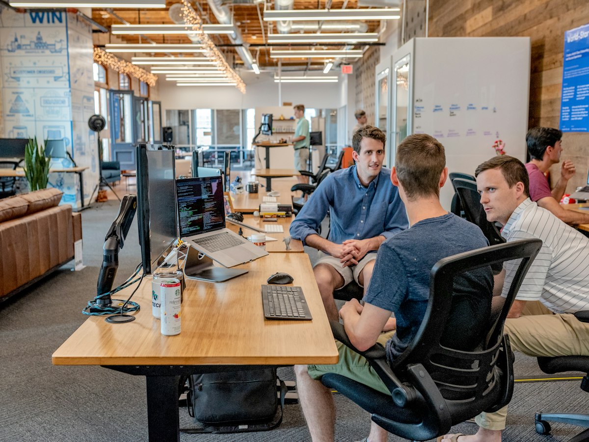 Engineering team reviewing issue tracker synchronization at a dual-monitor workstation