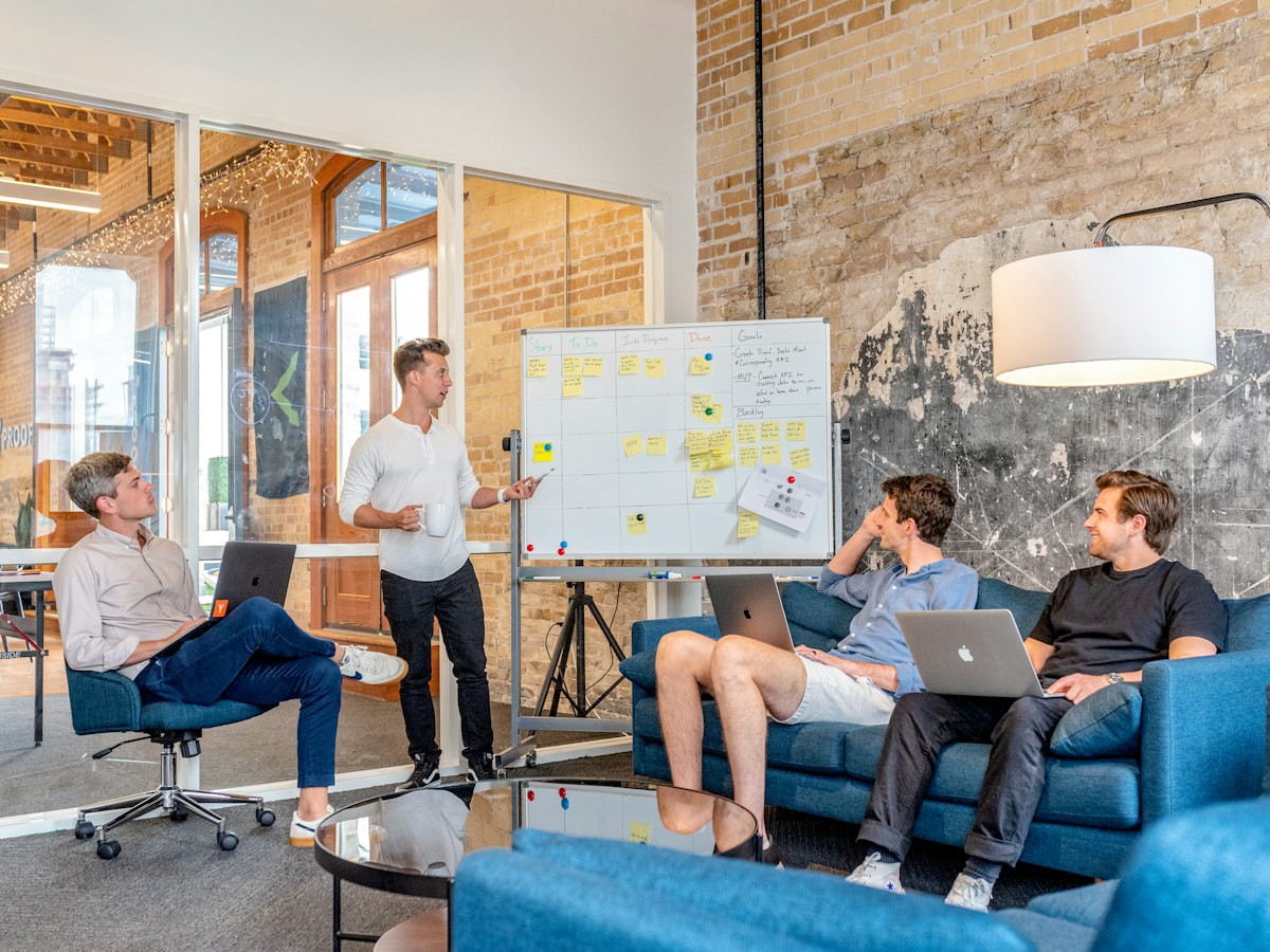 Cross-functional team reviewing sprint commitments and roadmap priorities around a whiteboard
