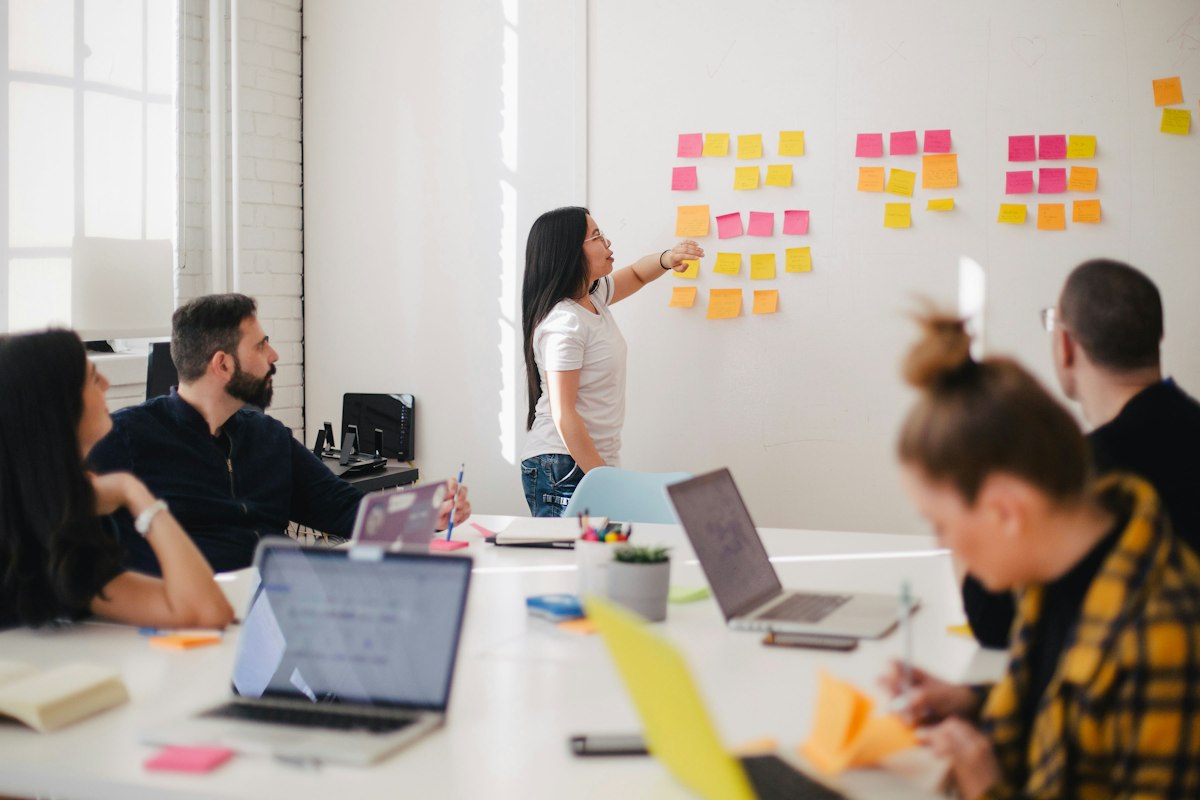 Product and operations leads mapping workflow stages during a boardroom planning session